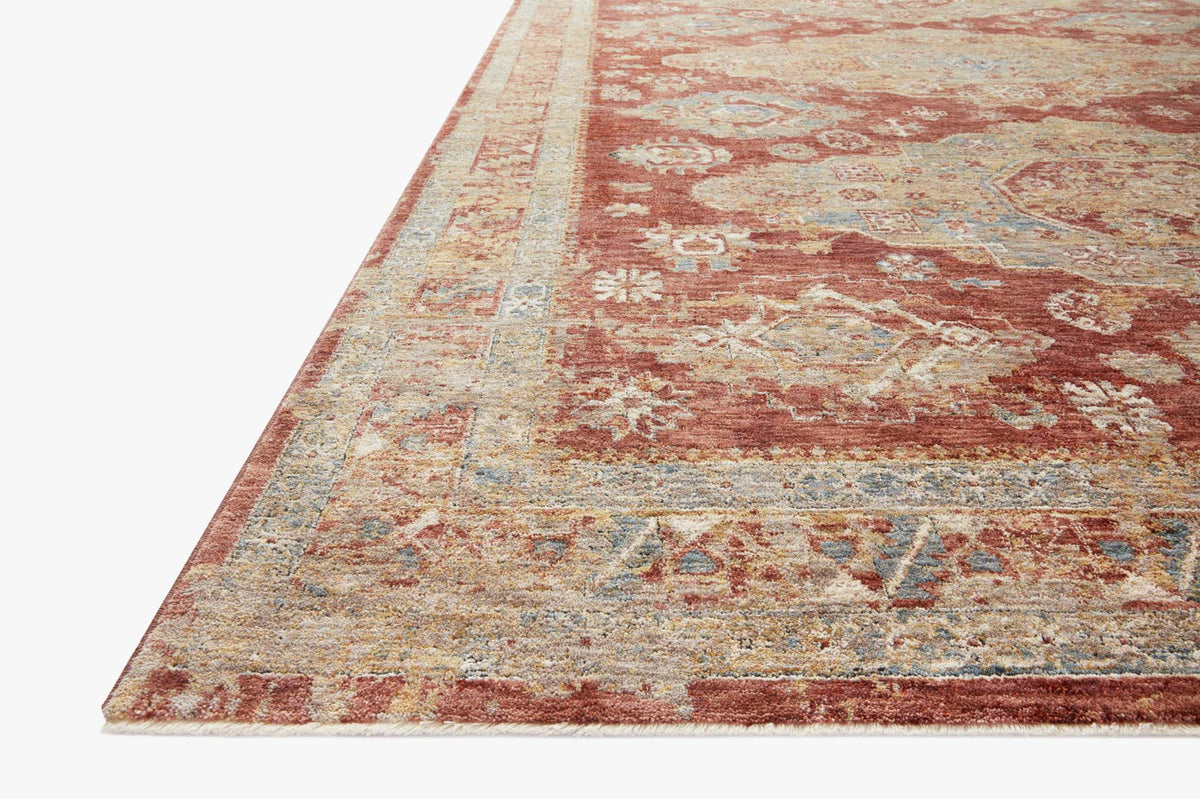 Gold and brick transitional rug, angled view showing distressed geometric and floral motifs