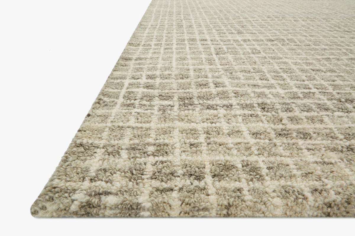 Granite transitional hooked rug with short textured pile and grid pattern, angled view.