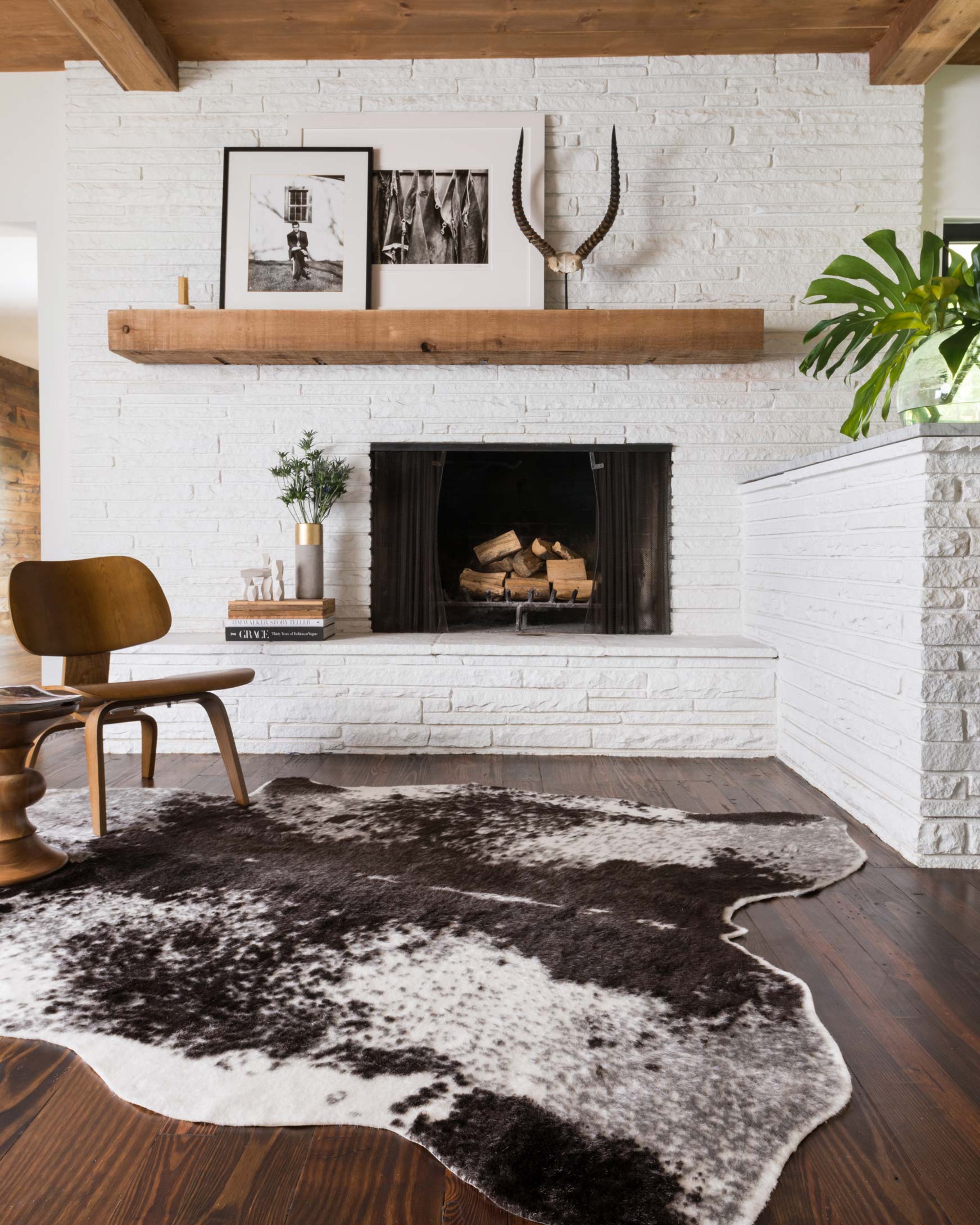 Ivory and charcoal speckled area rug on wood floor with irregular cowhide shape