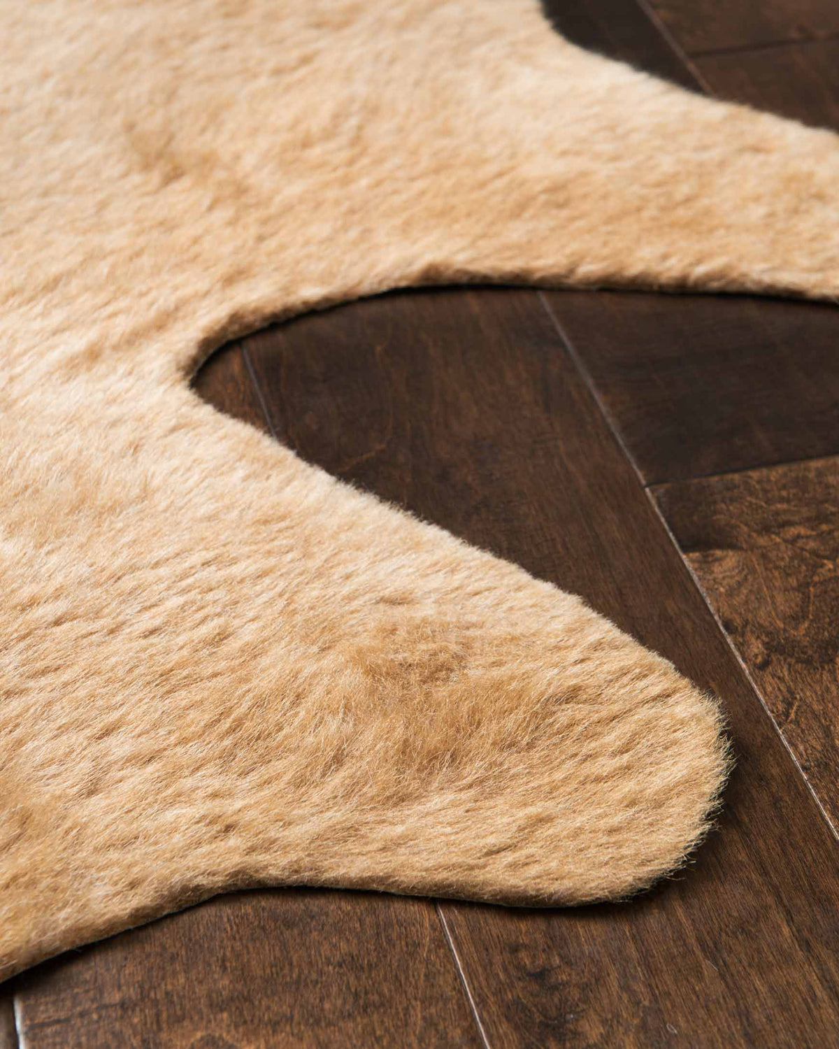 Tan power-loomed rug with plush shag texture, corner edge view