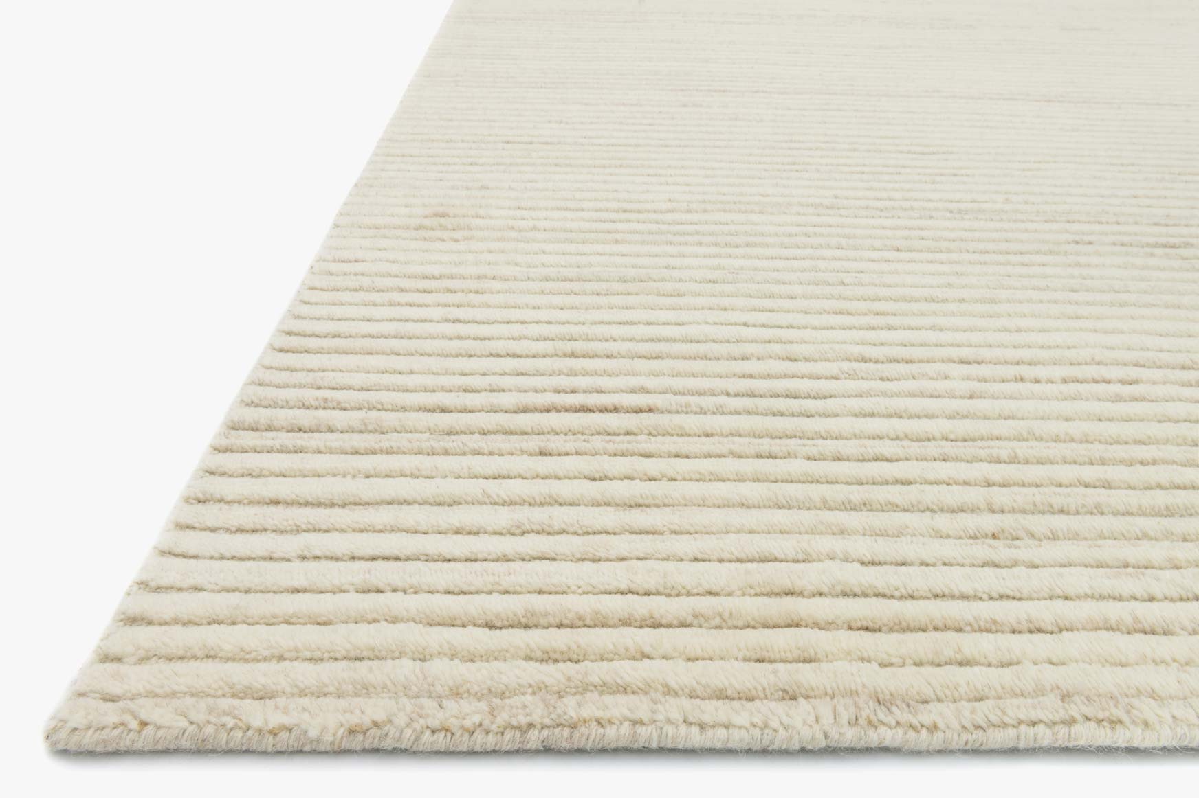 Ivory hand-loomed rug corner with visible low-pile stripe weave detail