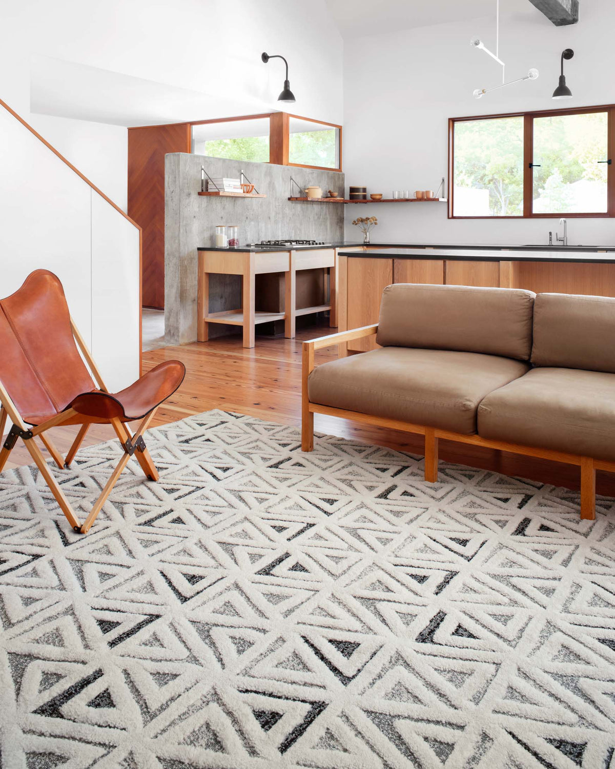 Geometric patterned rug in cream with navy triangles, shown laid out