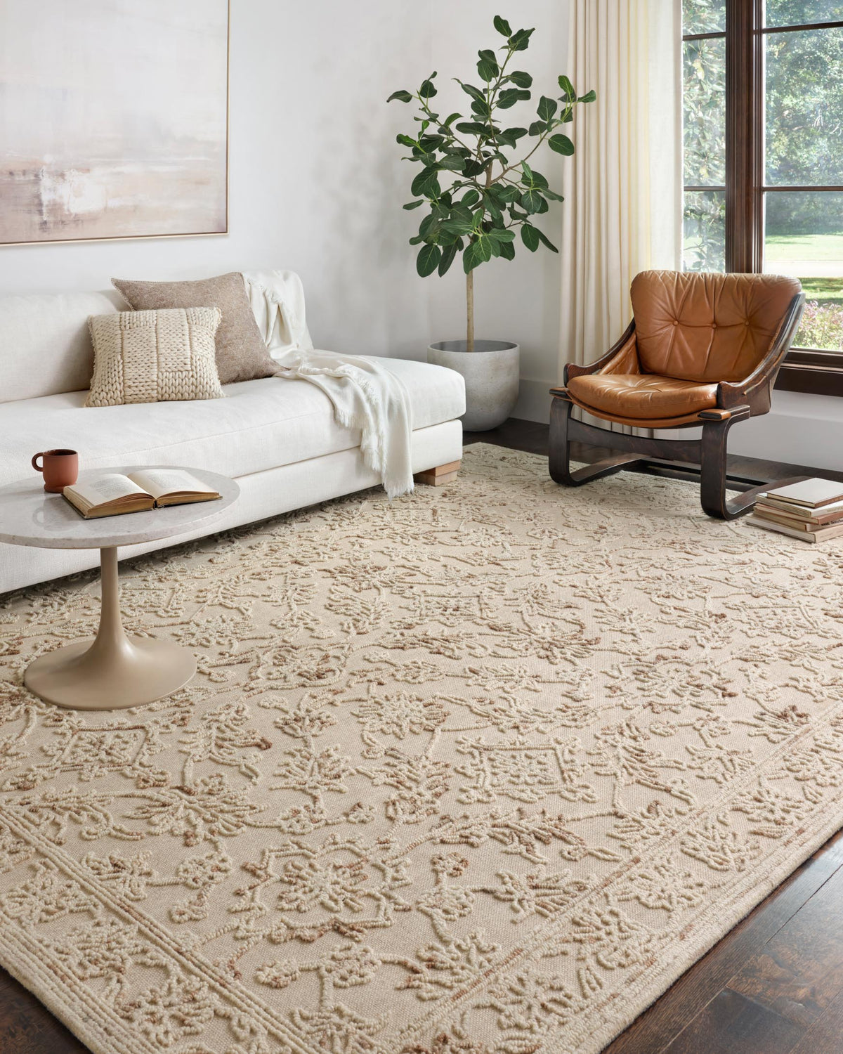 Traditional hooked rug with raised floral and vine pattern in natural tan and muted sage.