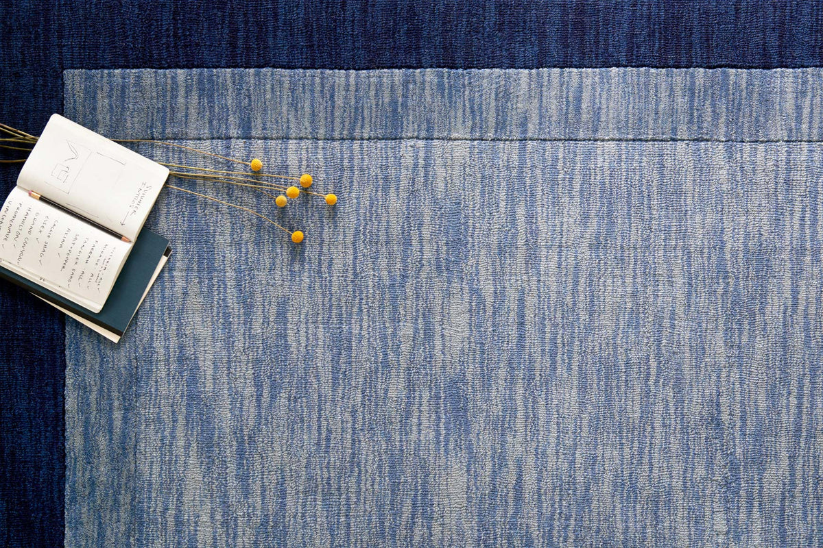Blue and navy hand-loomed rug with dense textured surface and subtle vertical pattern