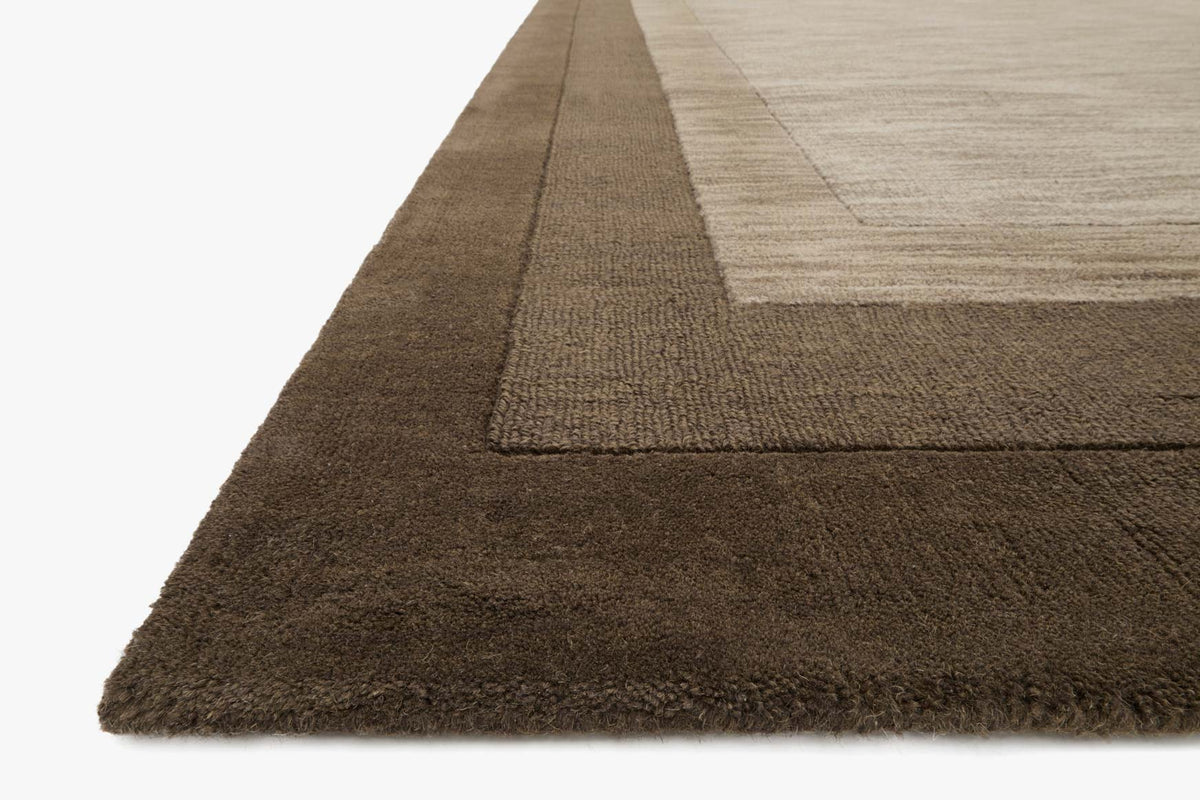 Corner detail of dark brown textured rug with light center, rectangular.