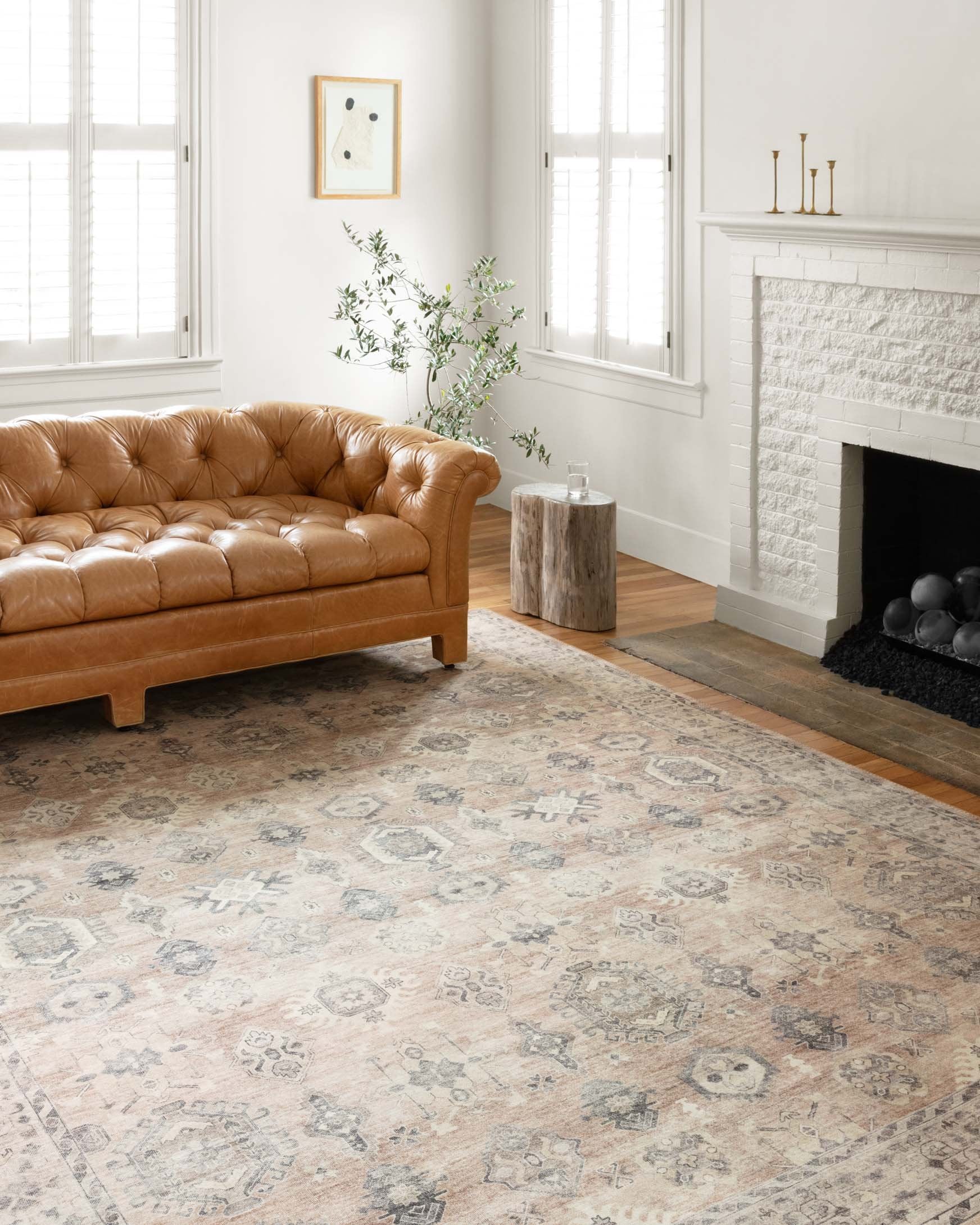 Traditional power-loomed rug in a room, large light beige distressed pattern with border.