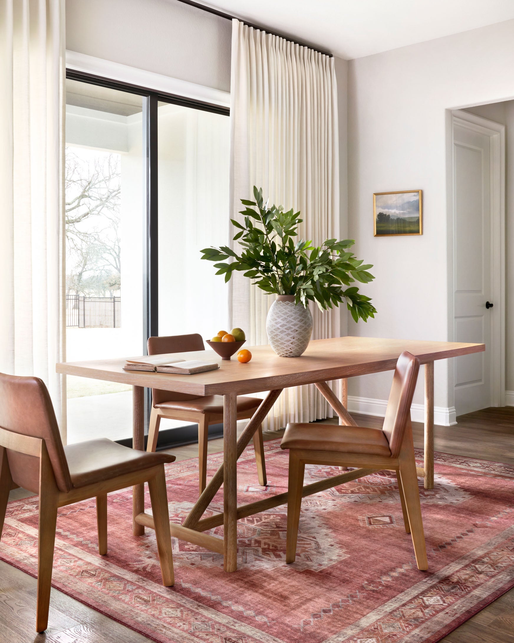 Geometric red-and-ivory area rug under dining table in a living room