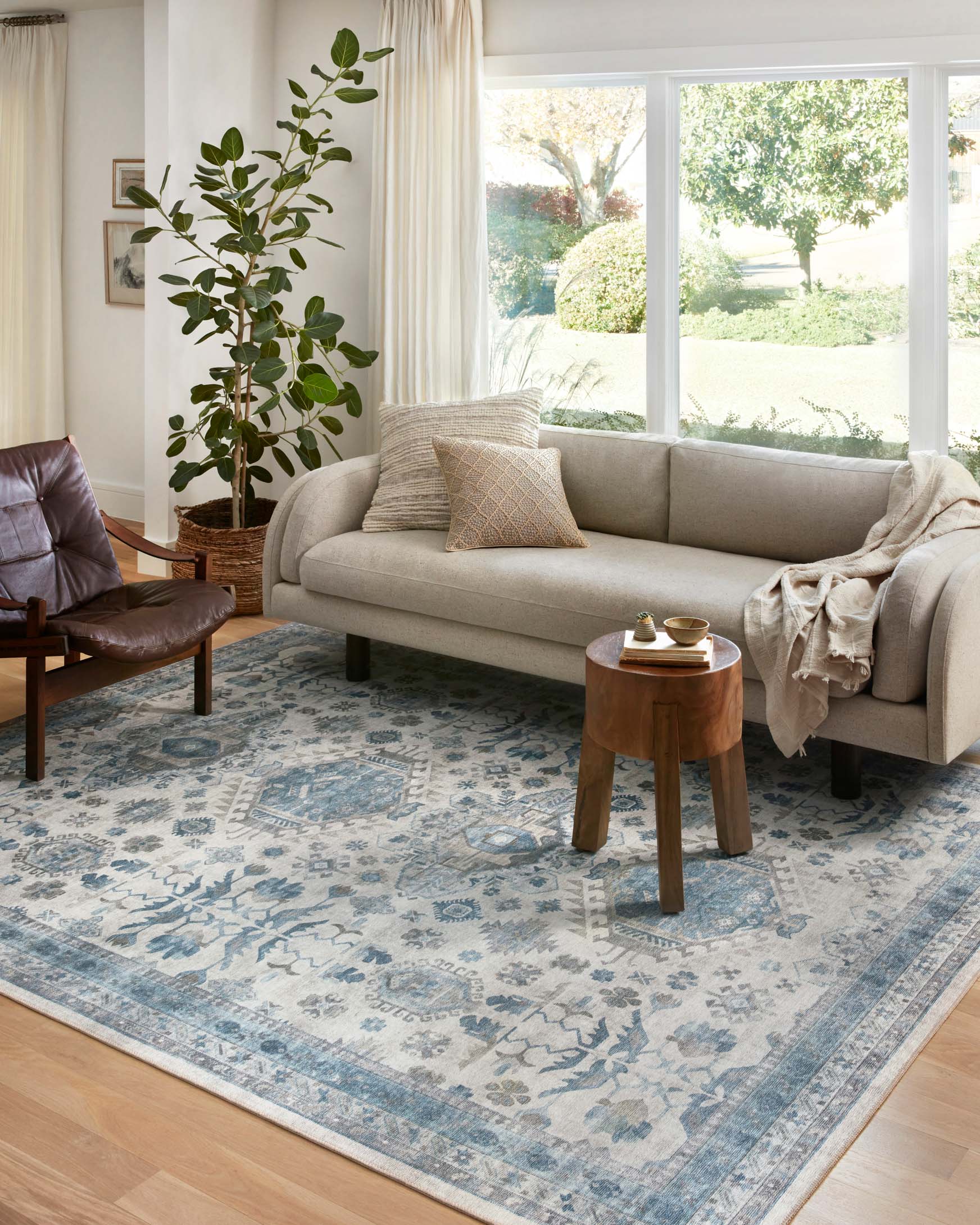 Ivory and ocean blue area rug under living room seating with detailed distressed pattern