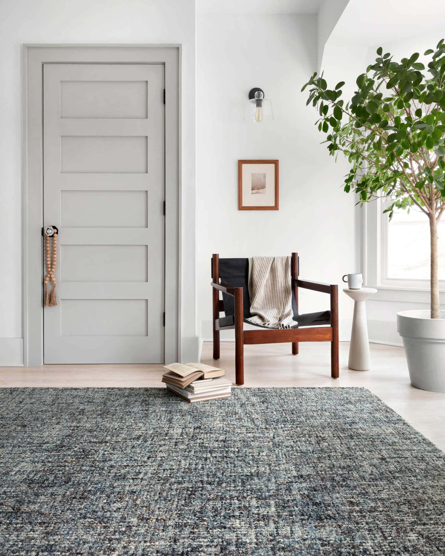 Denim-and-charcoal hand-tufted area rug in room, low-pile speckled texture