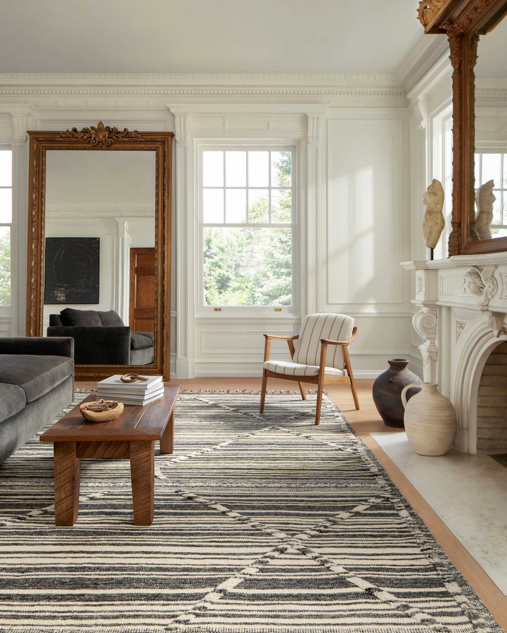Ivory and dark charcoal geometric rug with diamond motif, striped bands, and tassel fringe