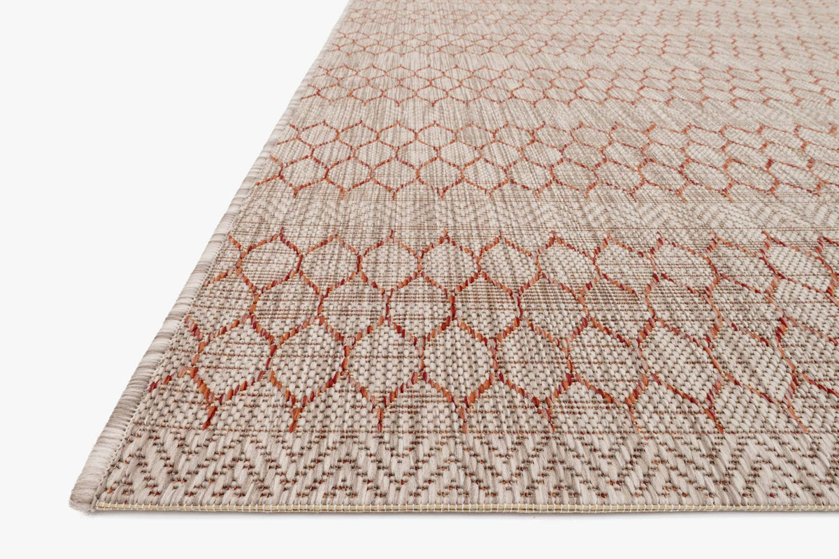 Beige rug corner with rust diamond pattern and textured braided border