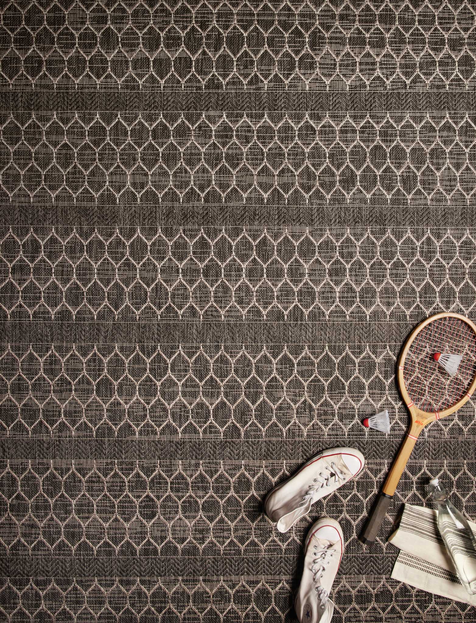 Black and gray rug with repeating lattice diamond pattern and horizontal bands