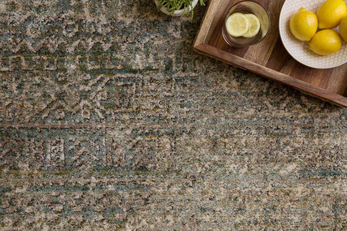 Close-up of ivory and sea blue-green rug with textured distressed abstract design