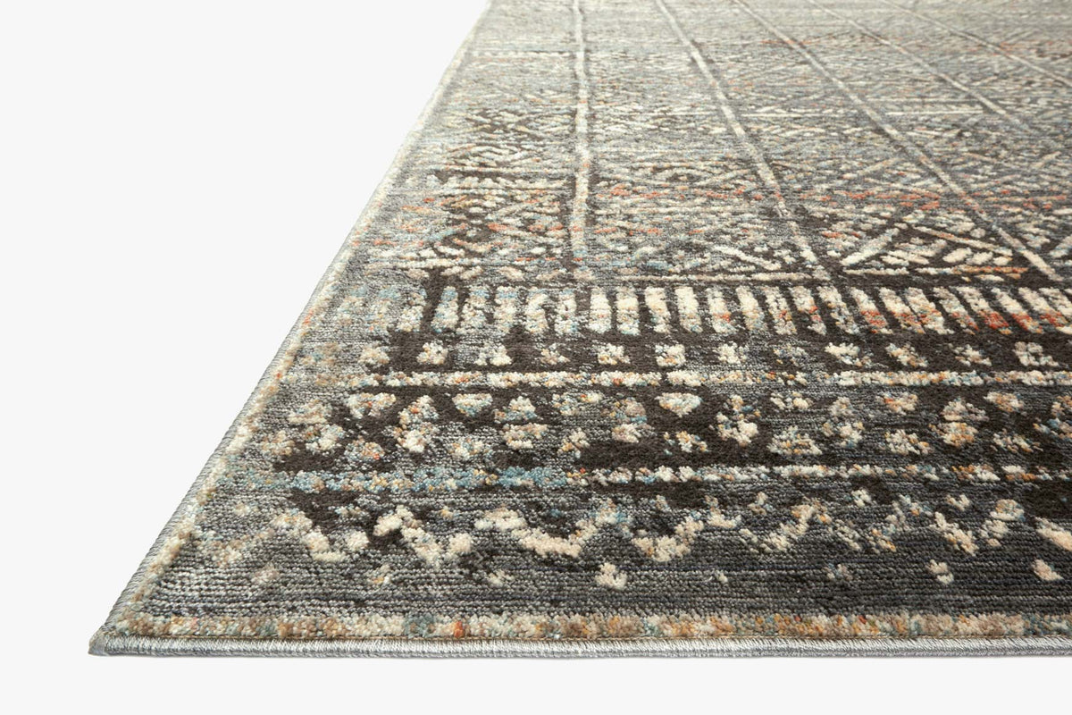 Charcoal and silver rug corner with geometric motifs and fringe edge border