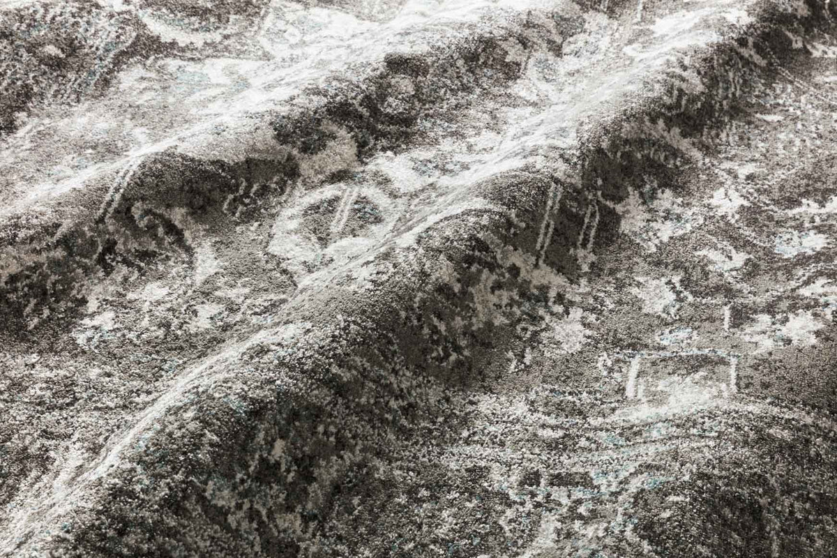 Close-up of charcoal and ivory rug texture with faded distressed pattern