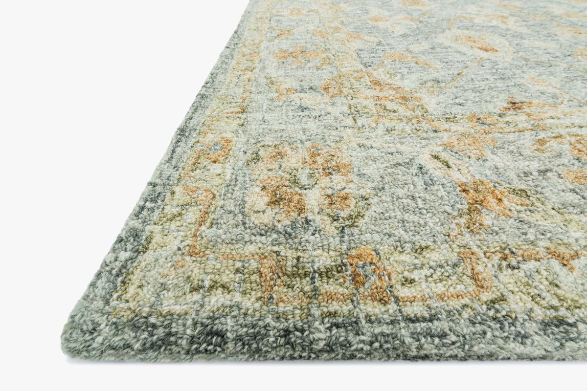 Corner of transitional hooked rug, textured light blue with tan flecks and border