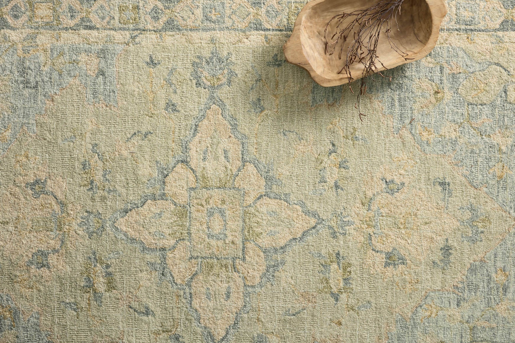 Seafoam green textured hooked rug with geometric medallion and distressed motifs