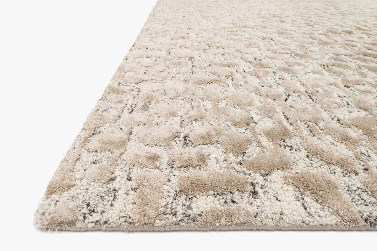 Hand-tufted area rug with ash and taupe abstract pattern, short pile, angled view
