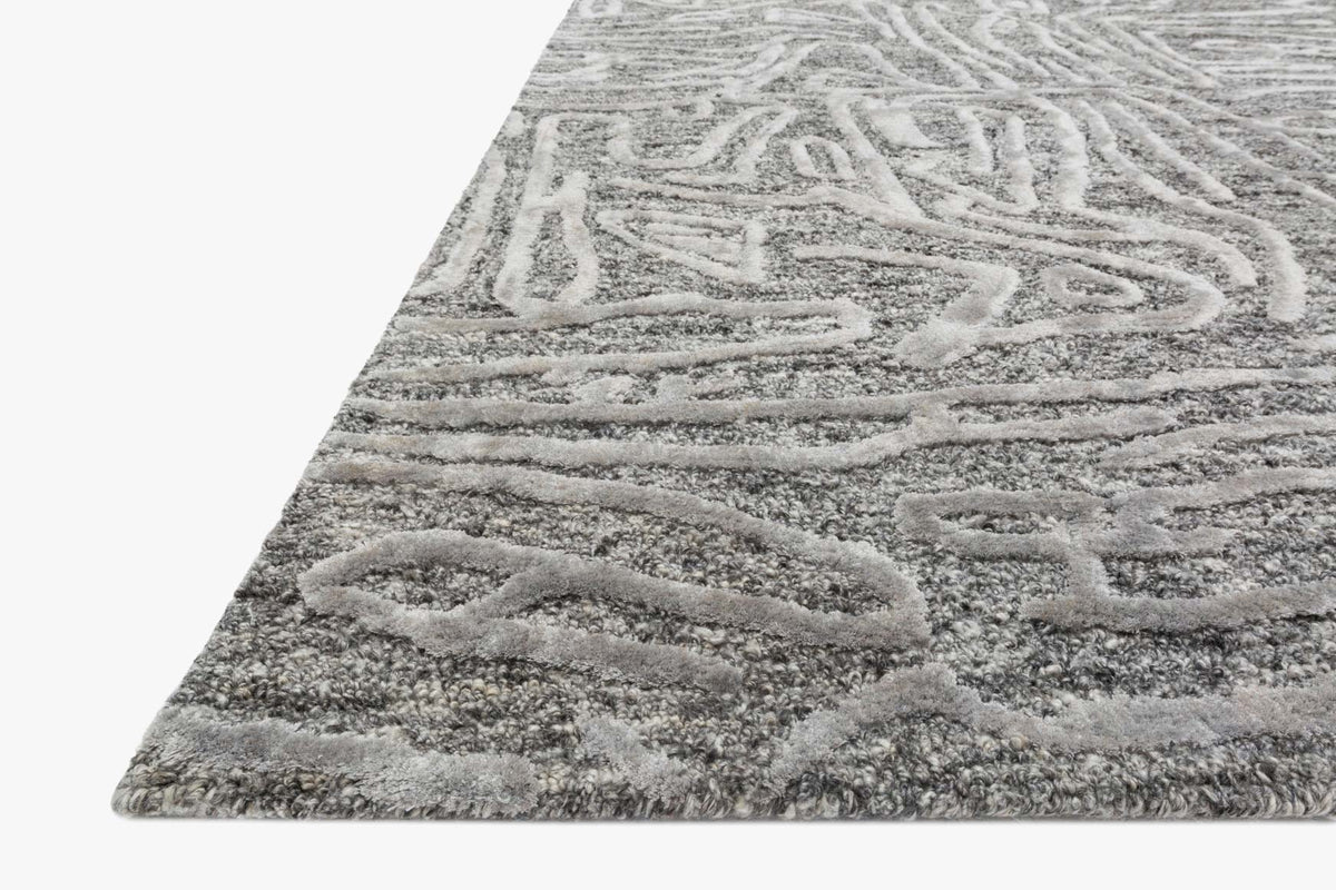 Grey hand-tufted rug corner with raised textured loops and abstract pattern