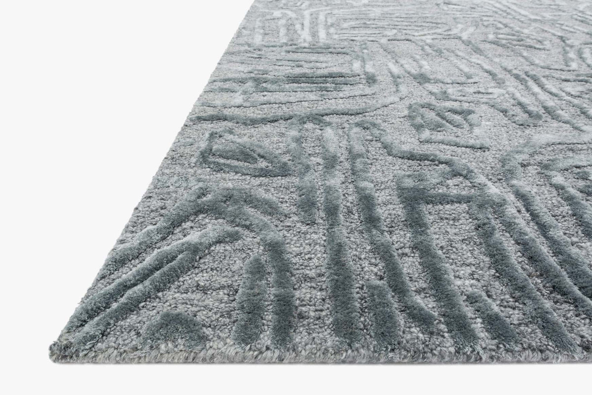 Light blue hand-tufted rug with abstract pattern and short textured pile