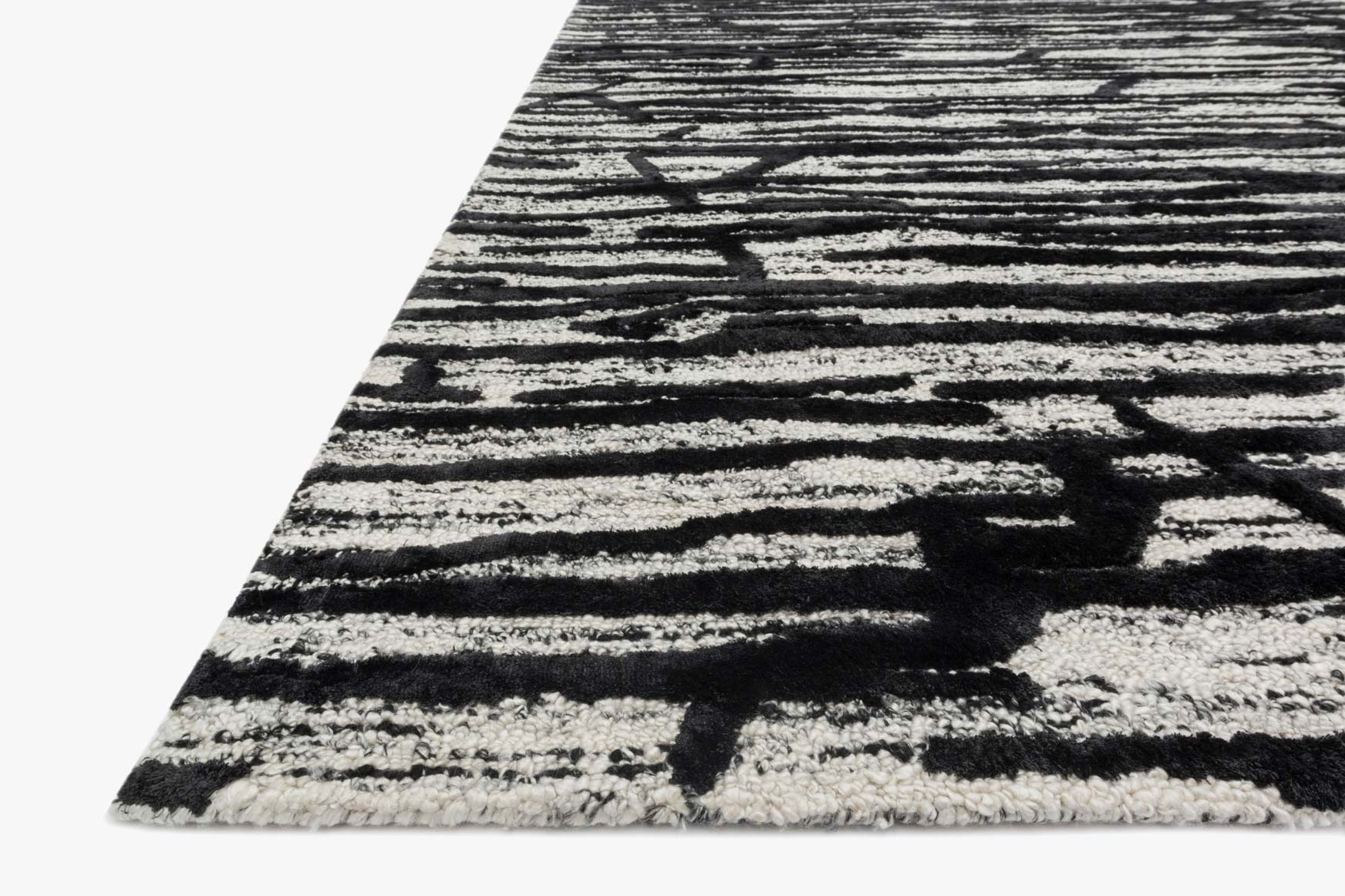 Hand-tufted rug corner view, ivory ground with black abstract crosshatch and stripes