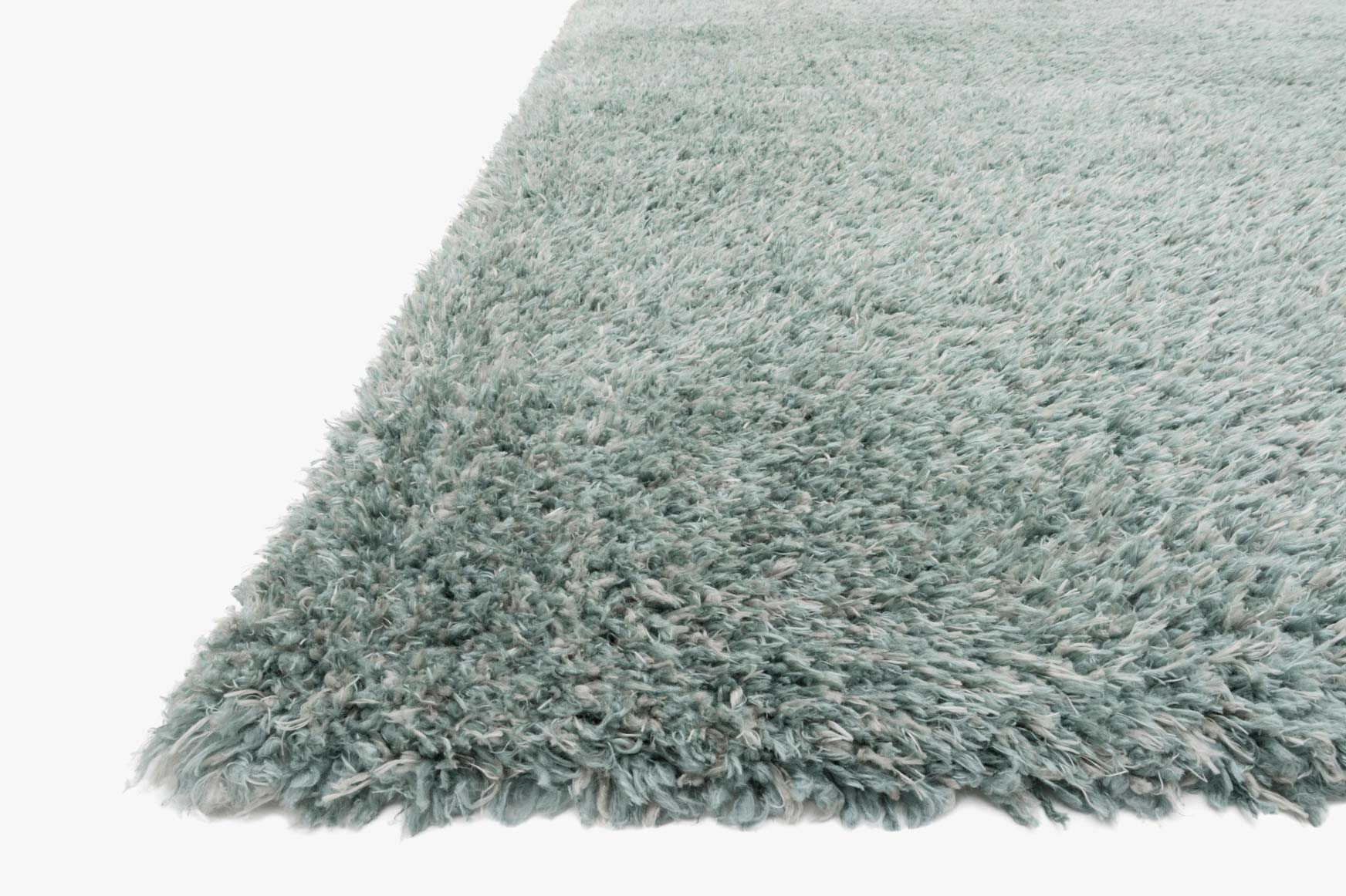 Corner view of blue-green shag rug with thick, plush fiber pile