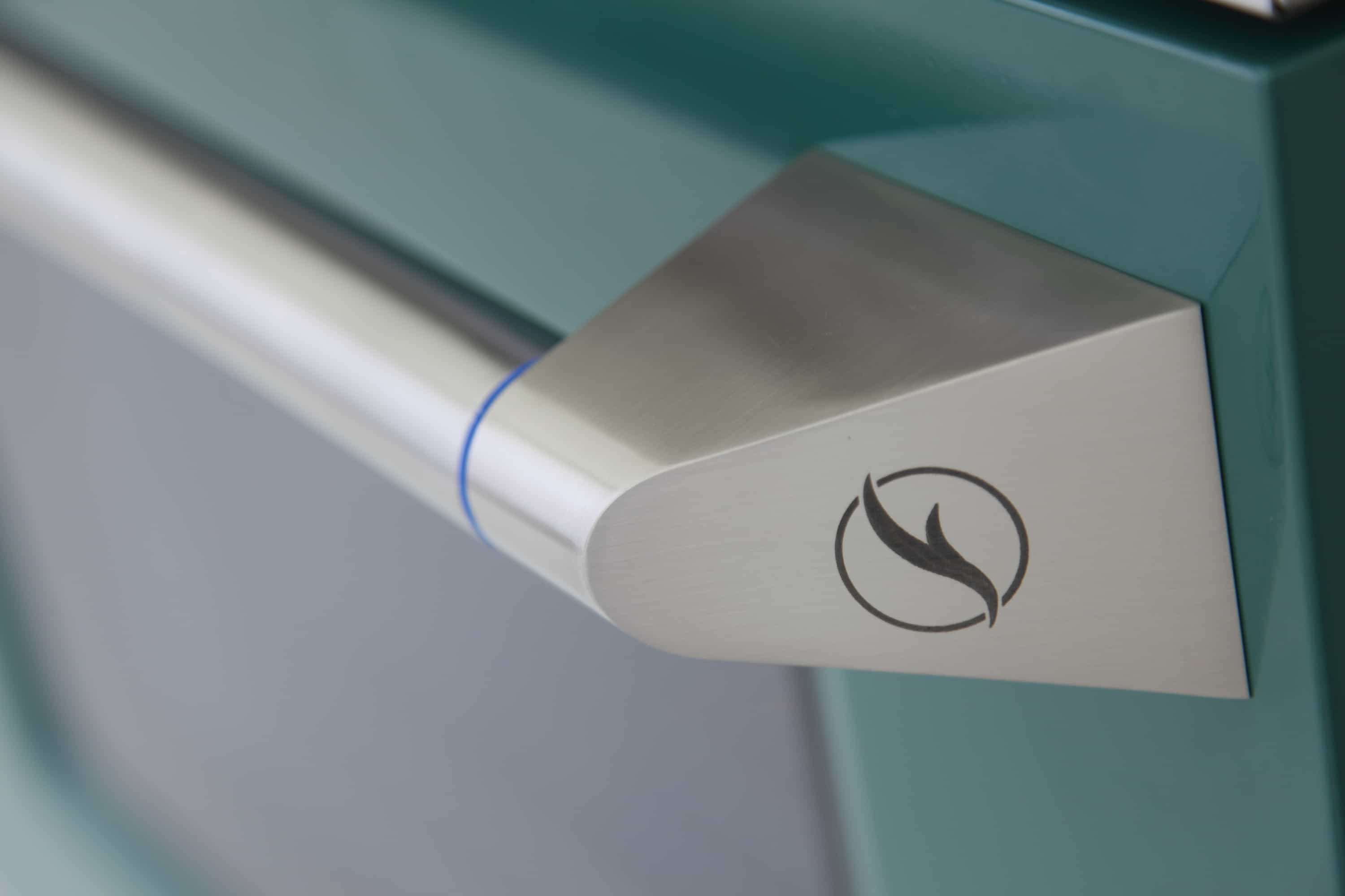 Dual-fuel range oven door handle with flame icon and smooth stainless steel finish