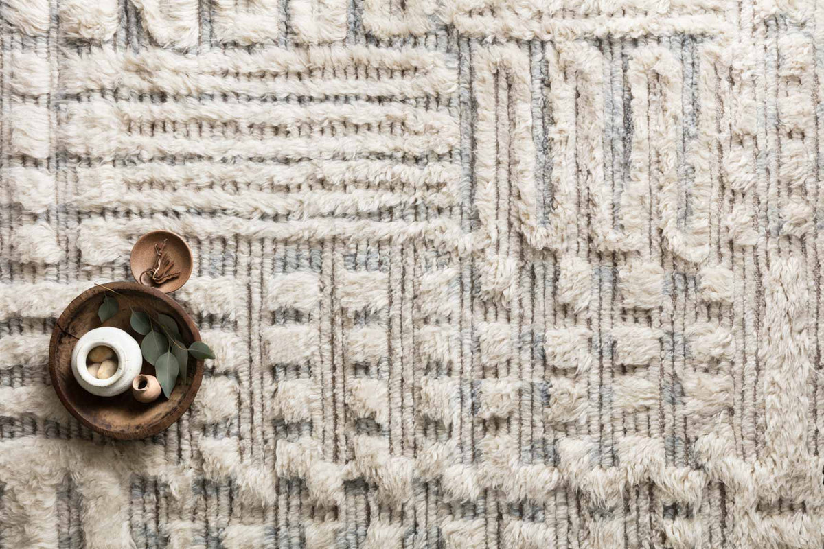 Hand-knotted rug close-up with ivory pile and light sky geometric lines texture