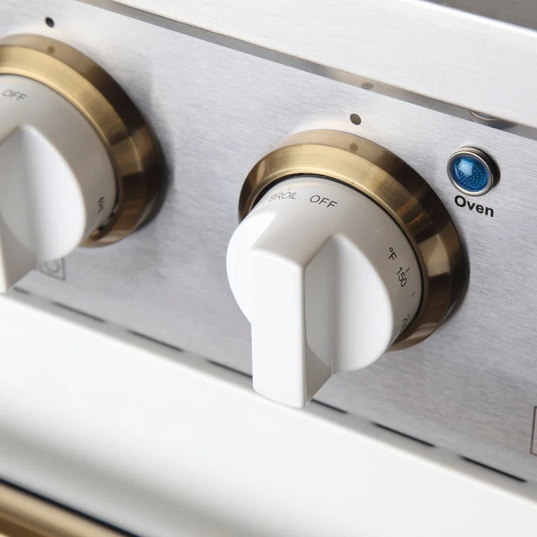 Stainless control panel with gold-rimmed knobs and labeled settings, 'Oven' dial.