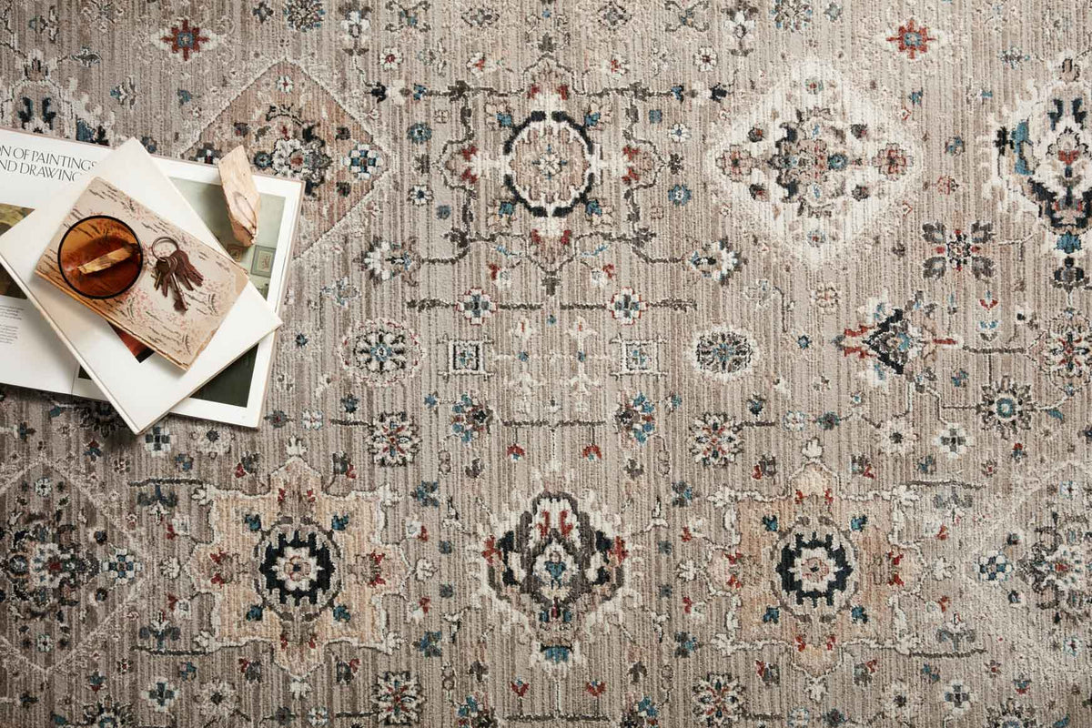 Power-loomed rug close-up with dove base, textured pile and blue, teal, red motifs.