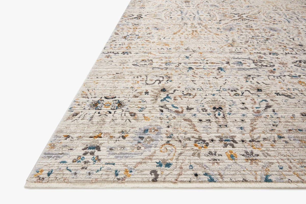Ivory power-loomed rug corner with faded ornamental motif and multicolor speckled details