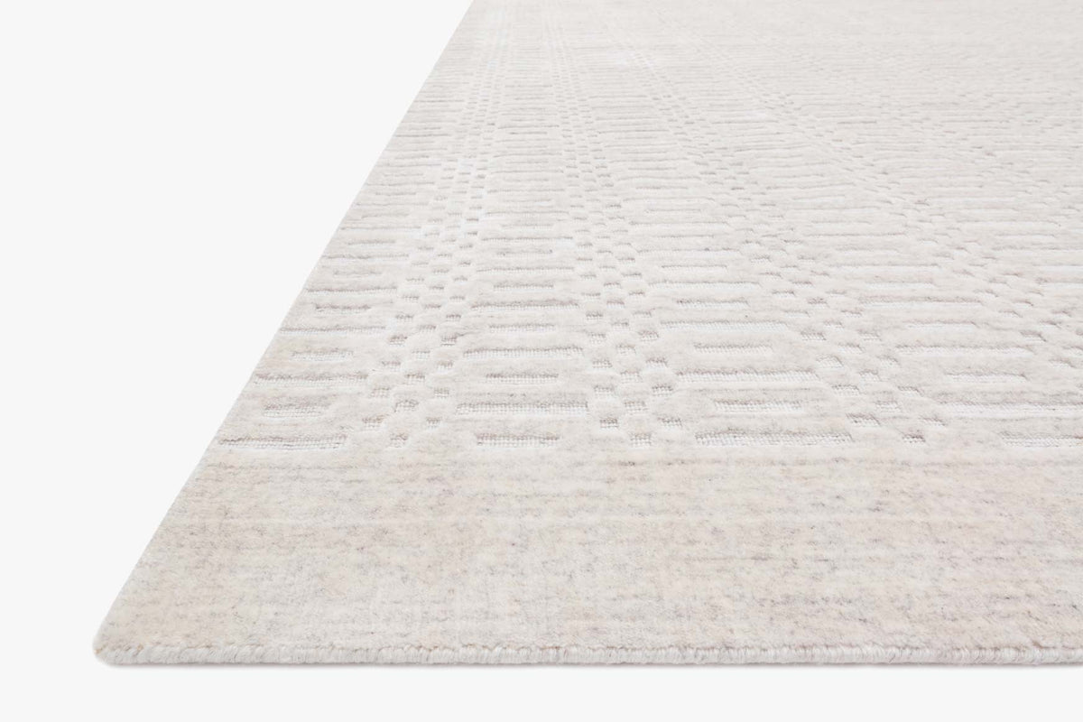Ivory hand-loomed rug corner view with low pile woven texture and soft border