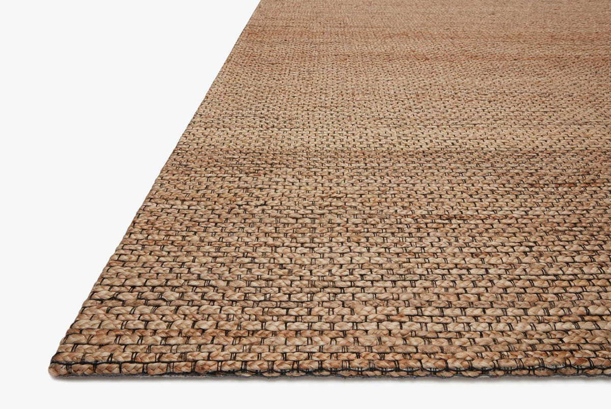 Natural hand-woven rug corner with flat weave edge and mottled tan and brown tones
