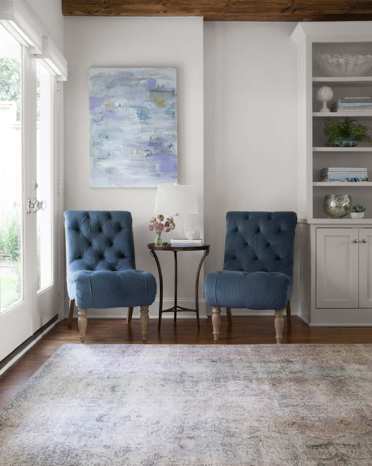 Silver and slate patterned area rug laid flat, distressed motif and border detailing.