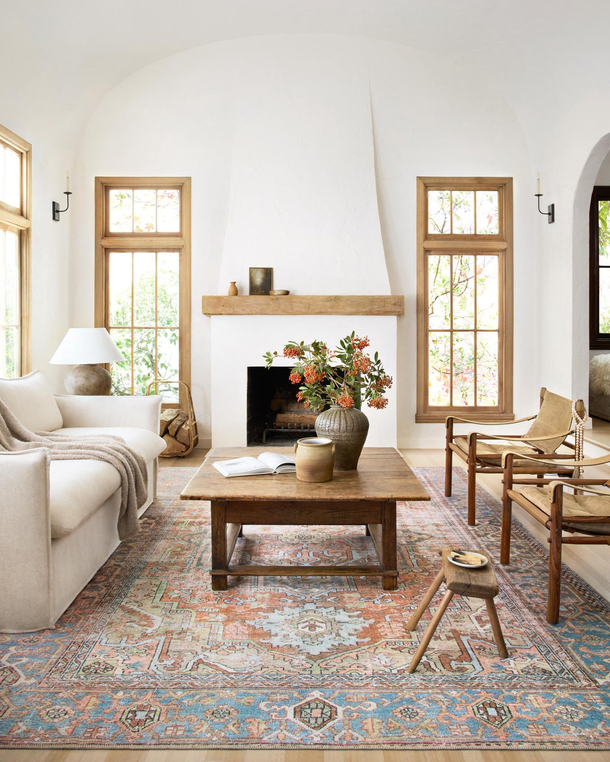 Traditional rectangular rug with distressed terracotta and blue geometric motifs and border.