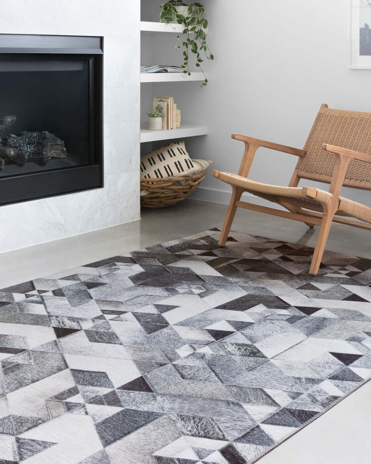 Grey and ivory geometric area rug in a room, repeating triangle cube design