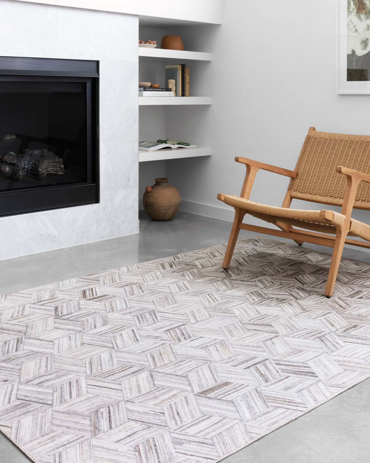 Light gray and ivory geometric rug with woven cube design, shown in living room
