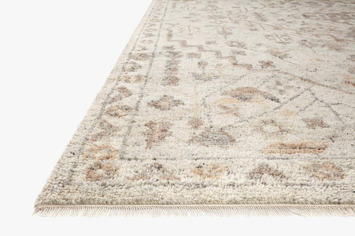 Traditional hooked rug corner with fringe edge, ivory and taupe textured pattern