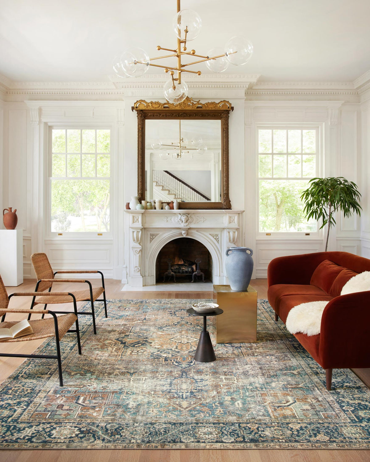 Traditional area rug featuring blue and teal distressed motifs with warm rust highlights