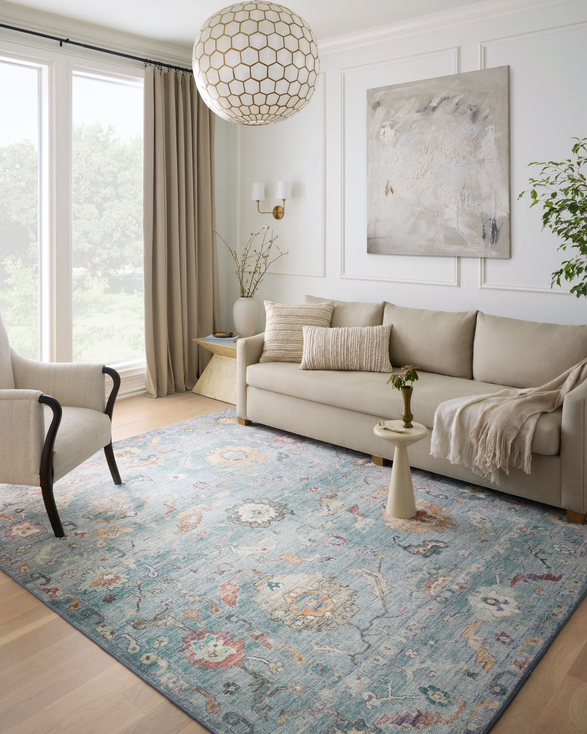 Denim blue rug with vintage medallion motifs and worn border on hardwood floor