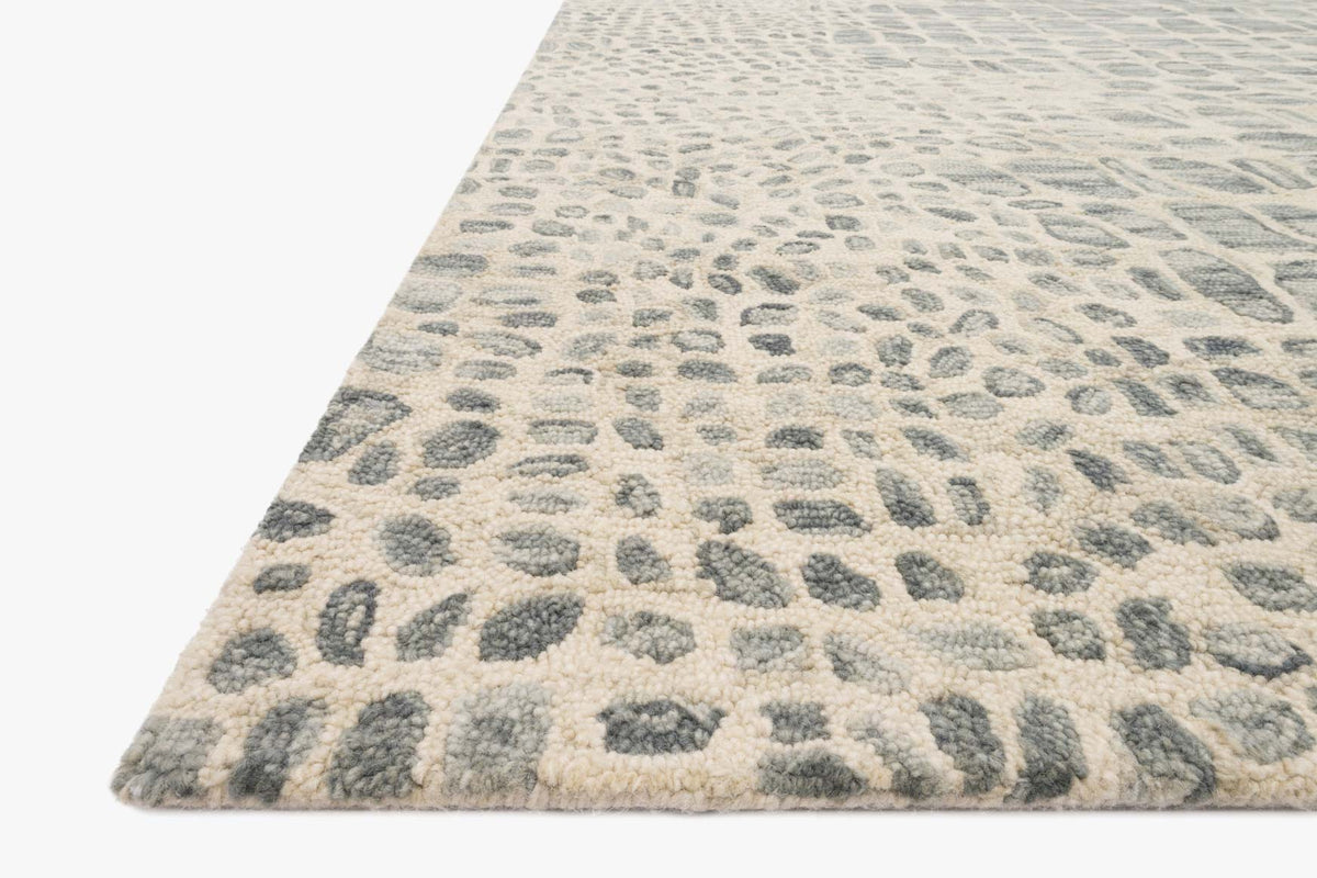 Contemporary hooked rug in silver-grey and ivory, abstract animal-print pattern, angled view.