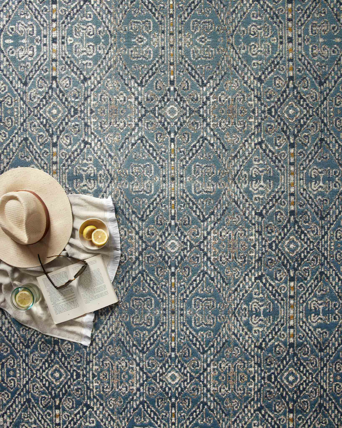 Blue indoor/outdoor rug close-up with repeating geometric pattern and cream accents