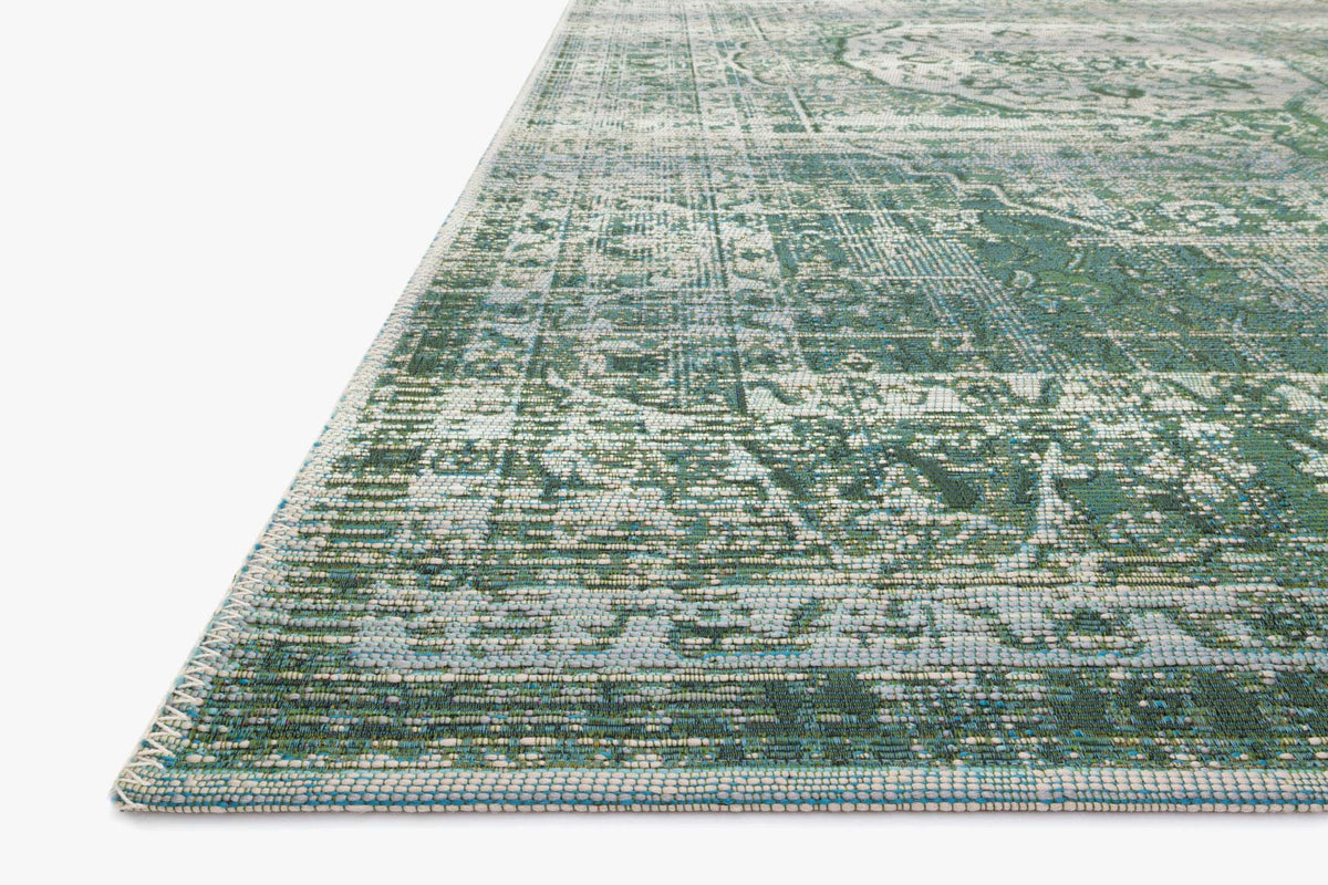 Edge view of green and mist power-loomed rug with dense abstract texturing