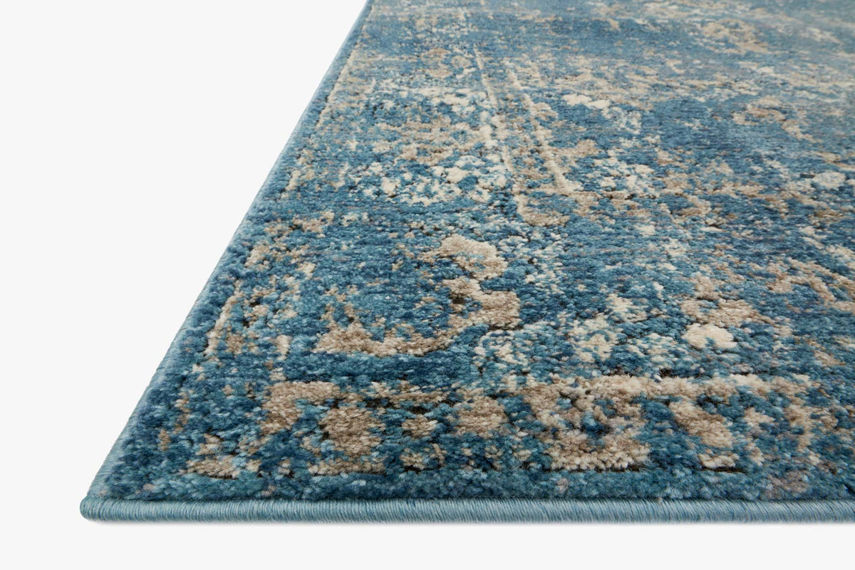 Blue and taupe distressed transitional rug with bound edge, angled view