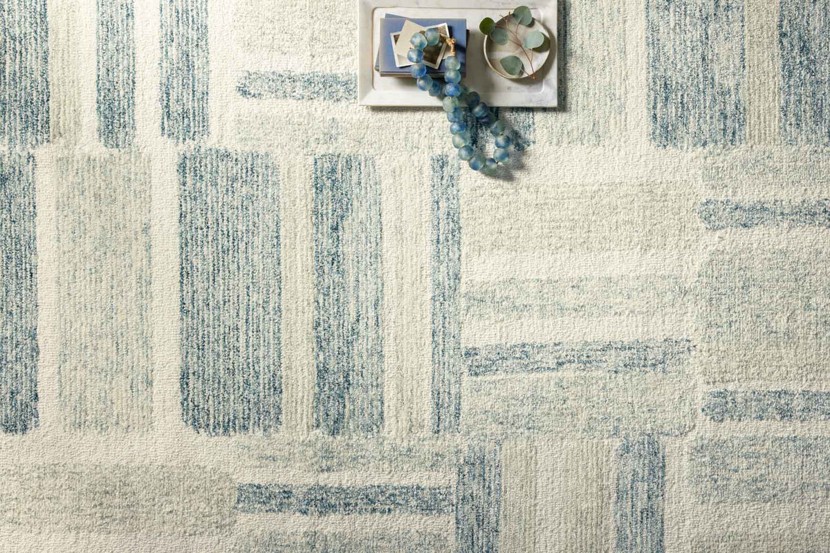 Light cream rug with aqua vertical and horizontal abstract stripes, tufted texture