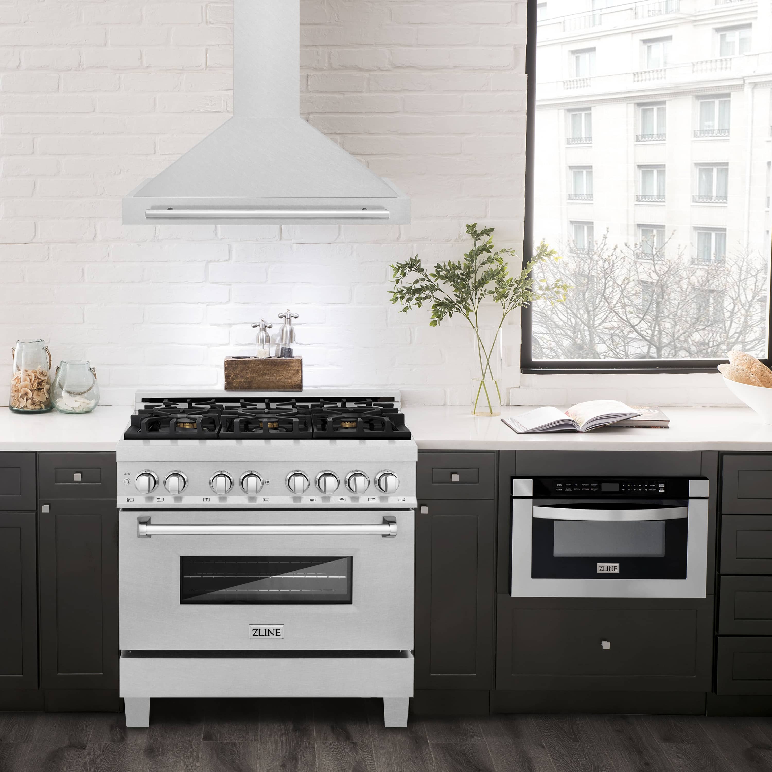 Satin stainless steel wall range hood with chimney and vent hood above cooktop.