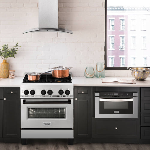 White dual fuel range with wall-mounted hood and built-in oven in dark cabinetry kitchen