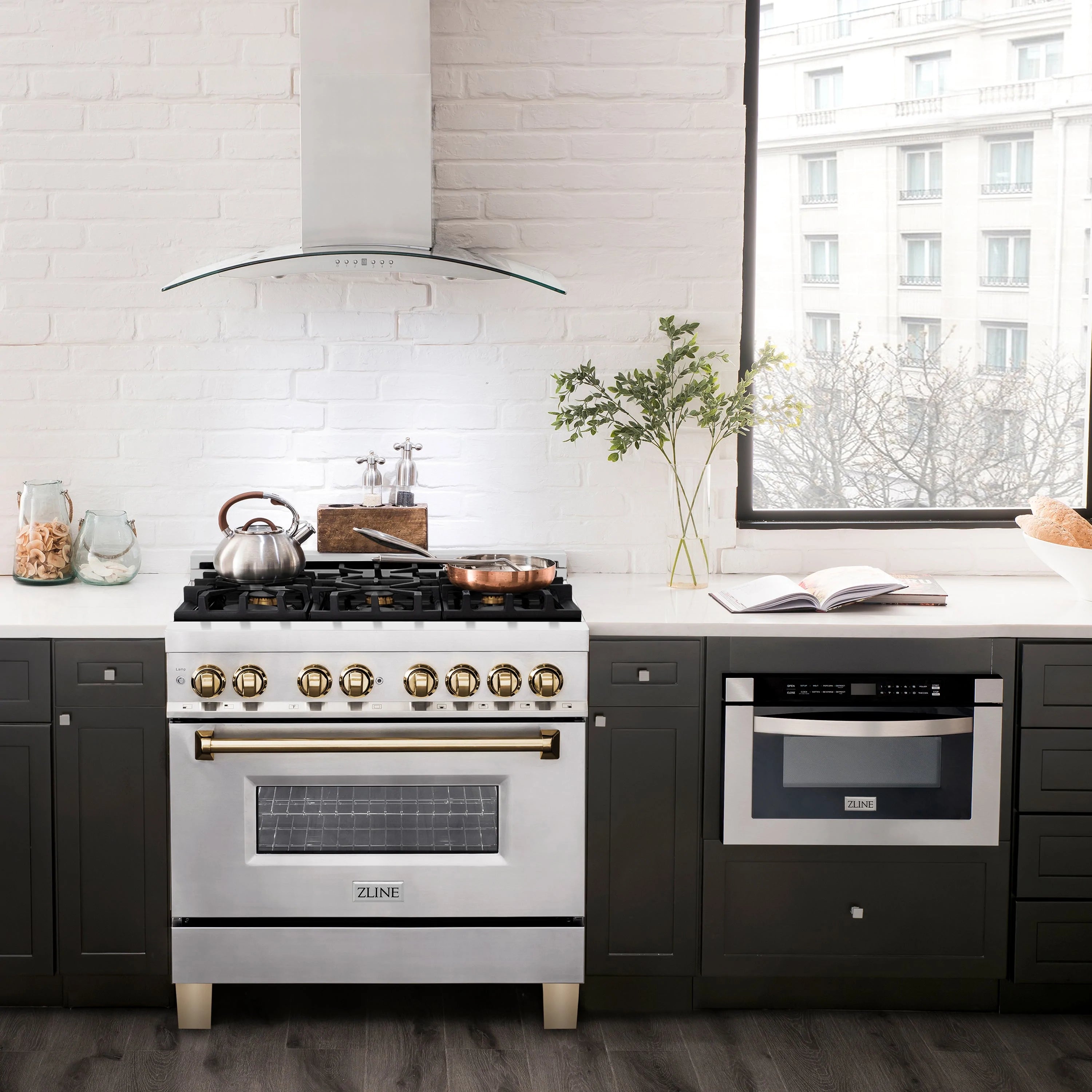 Stainless steel dual fuel range with gold knobs and wall mounted range hood