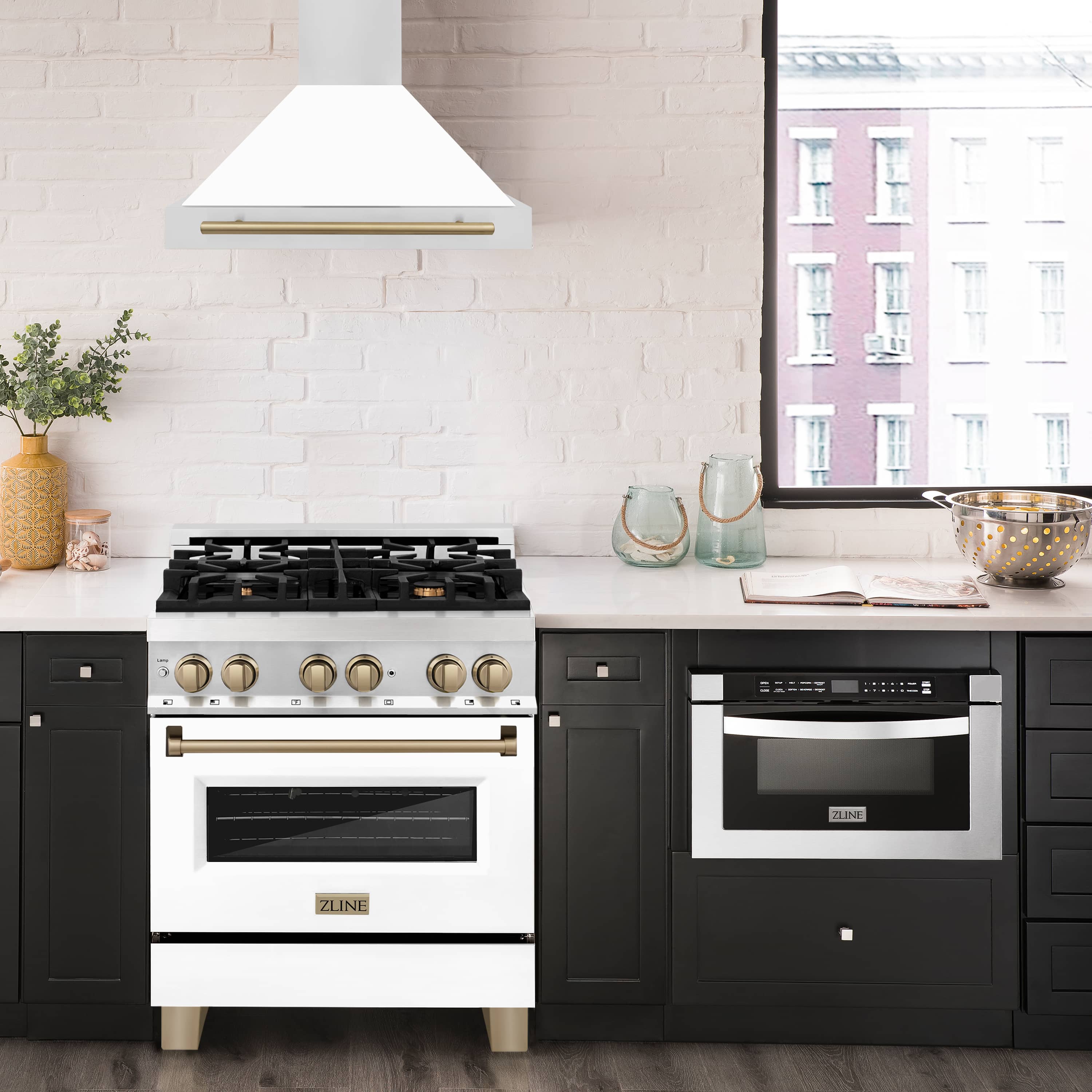 Stainless and white wall range hood with champagne bronze handle trim above stove