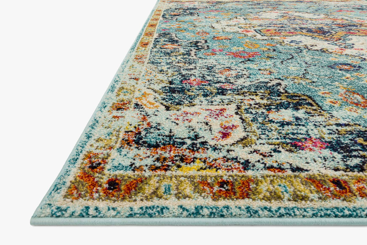 Blue and midnight rug with ornate distressed pattern, angled corner view